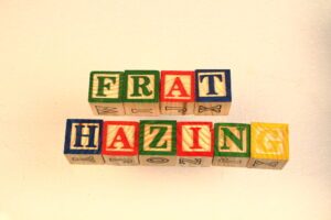 Children’s blocks spell out “frat hazing,” leading one to wonder if it is illegal for frats to haze.