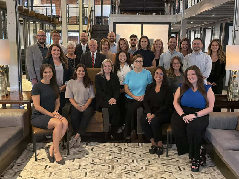The Cooper Elliott Team gathered in office lobby